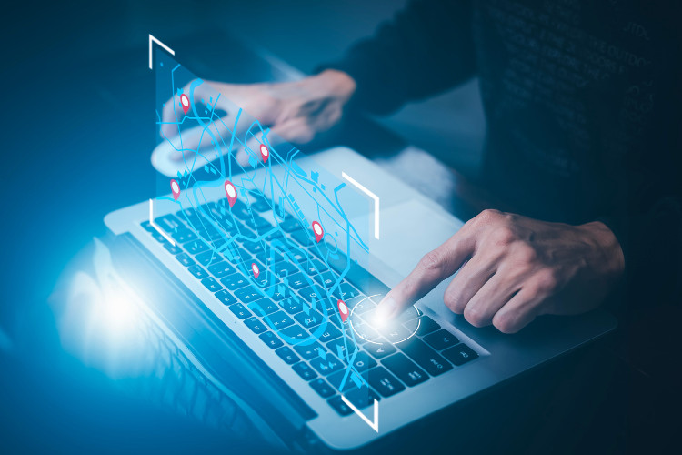 Man using laptop with virtual world and model map with location point GPS app icon