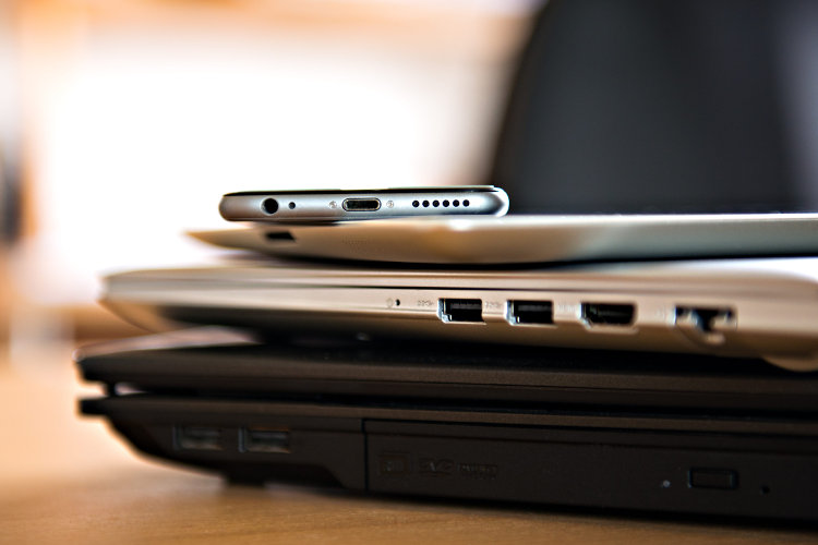 Pile of different computers and phone on table