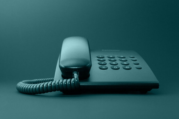Black solid office phone with cord isolated and toned in green
